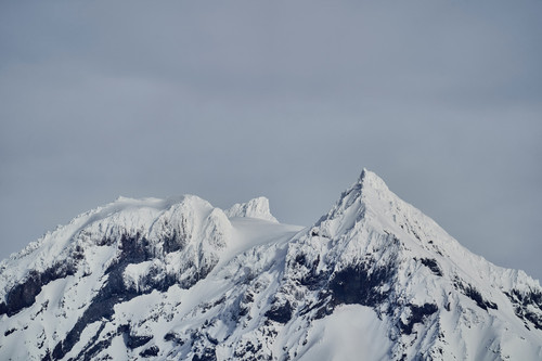 a snowy mountain tops with a grey sky.jpg