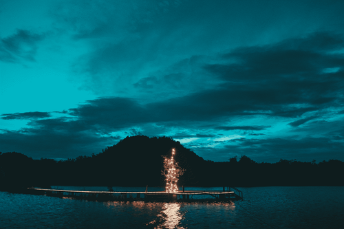 a body of water with a lit up tower in the middle.png