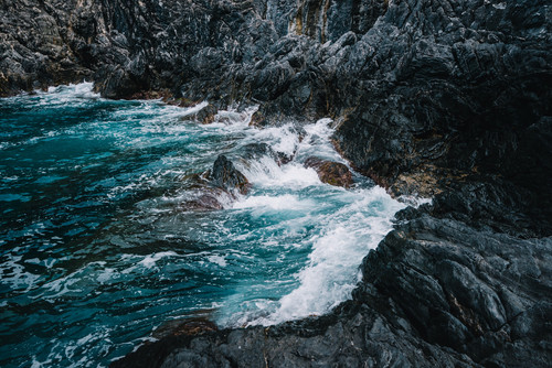 a rocky shore with waves crashing on rocks.jpg