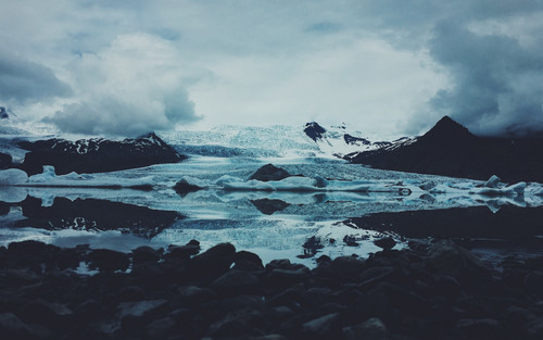 a snowy mountain with a body of water.jpg