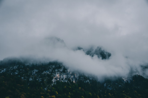 a mountain with clouds and trees.jpg