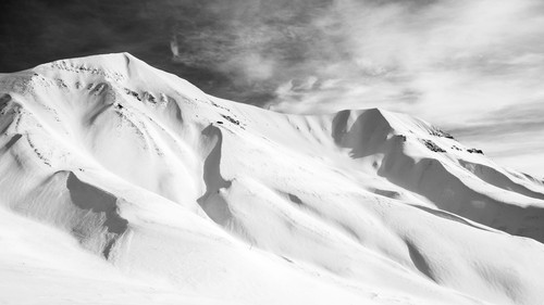 a snowy mountain with clouds in the sky.jpg