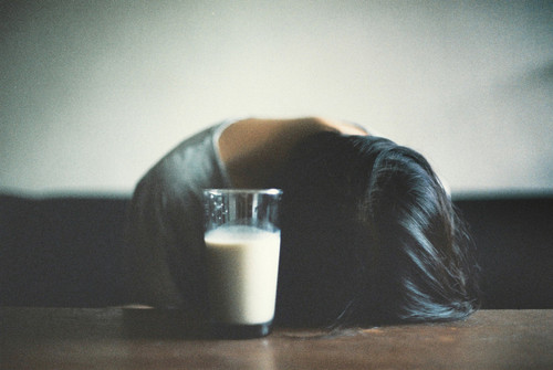 a woman lying on the floor with her head on a glass of milk.jpg