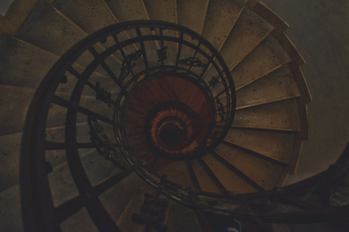 a spiral staircase with a black railing.jpg