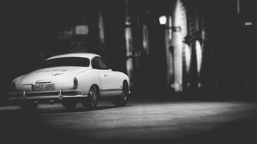 a white car parked on a brick road.png