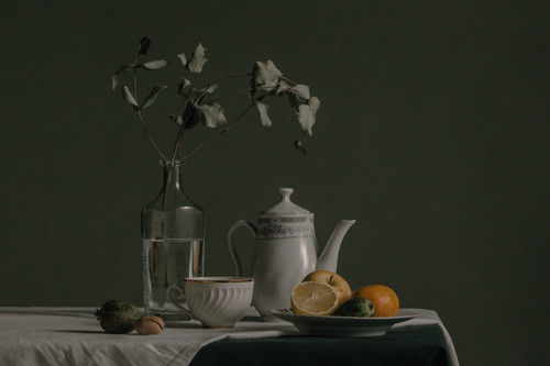 a table with a vase of fruit and a pitcher of water.jpg
