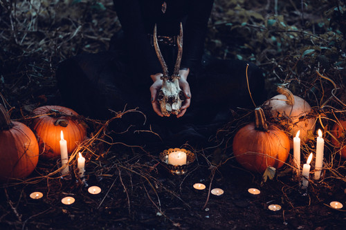 a person holding a skull and pumpkins.jpg