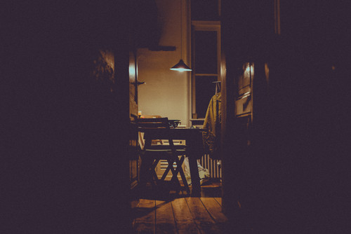 a dark room with a table and chairs.jpg
