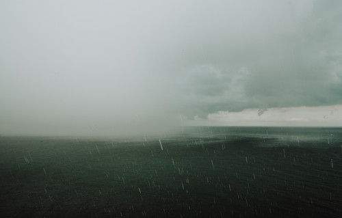a body of water with rain falling on it.jpg