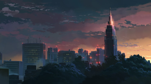 a city skyline with a tall tower lit up at night.jpg