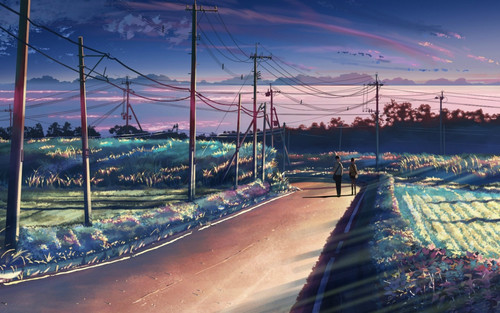 a couple of people walking on a road with power lines and telephone poles.jpg