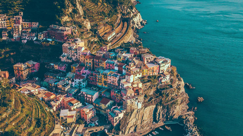 a colorful buildings on a cliff by the water.jpg