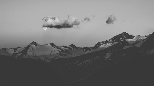 a moon in the sky above mountains.jpg