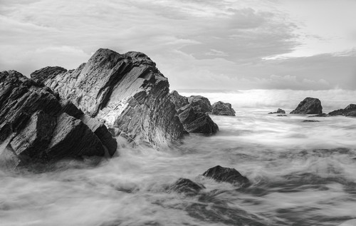 a rocky beach with waves crashing onto rocks.jpg
