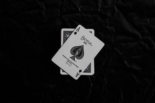 a pair of playing cards on a black surface.jpg