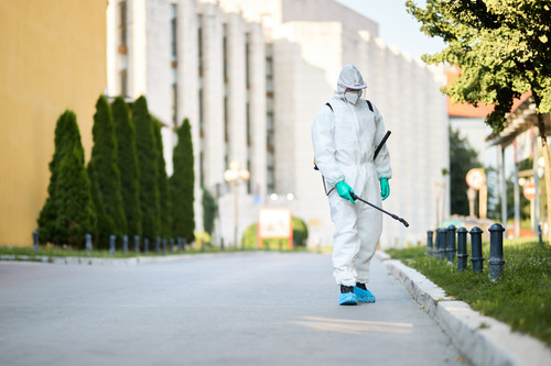 man protective suit disinfecting city streets coronavirus pandemic.jpg