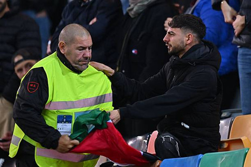 UDINE, ITALY - OCTOBER 14: A security staff member removes a Palestinian flag from a fan before the .jpg