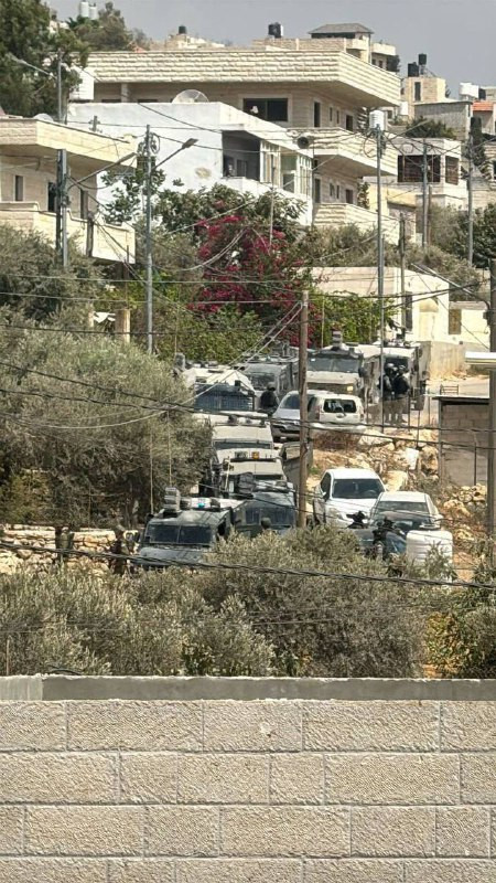 صورة لاقتحام قوات كبيرة من جيش الاحتلال بلدة قطنة شمال غربي القدس ومداهمة منزل يشتيه أنه أحد منفذي عملية إطلاق النار قرب مستوطنة راموت...