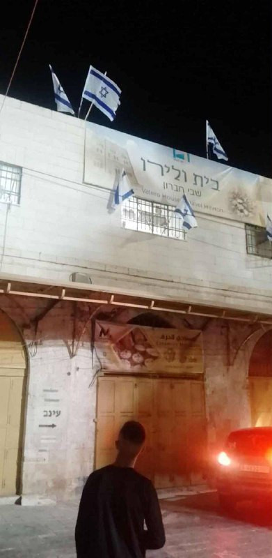 المستوطنون يرفعون أعلام الاحتلال على منزلٍ استولوا عليه، في البلدة القديمة بمدينة الخليل....