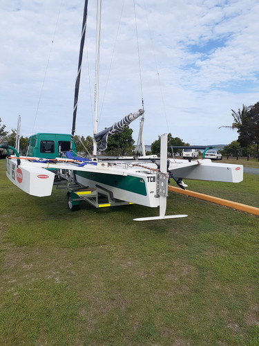 Adventure Trimarans A600

Find out more at https://www.adventuretrimarans.co.uk

Here we can see it securely on the road / launching trailer with the floats deployed to full width.

The rear lifting foil on the rudder can be clearly seen in its fully raised position so it can still access shallow waters safely.

The rudder rake is controlled by a remote switch on each tiller so  you can adjust the angle dynamically whilst sailing from the bench seats.

The lightweight, removable bench seats can be seen on the edge of the floats - they lift you up and out reducing your exposure to spray and getting your weight further out to help keep the boat flat at speed.

This will make fast adventure cruising a breeze as no trapezing is required!