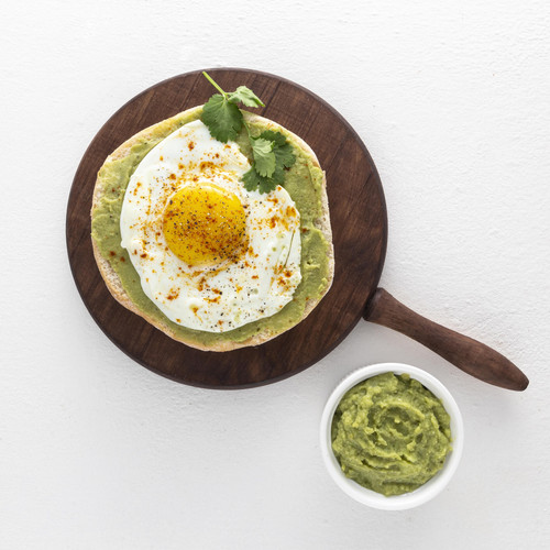 flat lay pita with avocado spread and fried egg on cutting board.jpg