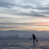 Silhouettes of kids playing hockey on frozen lake at sunset, Kirchsee, Bavaria, Germany 1080p