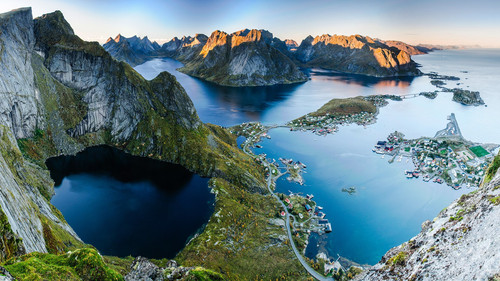 Sunset aerial view from Reinebringen ridge on mountains and village of Reine in Lofoten islands, Nor