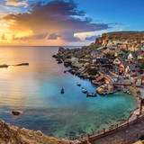 The famous Popeye Village in Anchor Bay at sunset with clouds, il Mellieħa, Malta 1080p