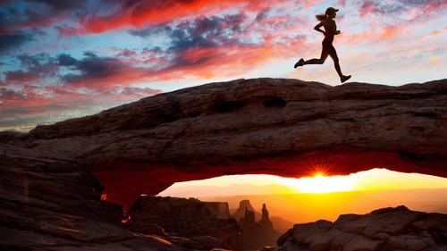 Young female runner running over Mesa Arch rock formation at sunset, Moab, Utah, USA1080p.jpg