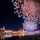 Fireworks lighting up night Sky with skyline of Dresden and reflections in river Elbe, Germany 1080p