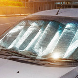 Protective reflective surface under the windshield of the passenger car parked on a hot day, heated 
