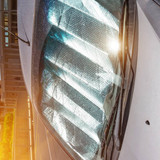 Protective reflective surface under the windshield of the passenger car parked on a hot day, heated 