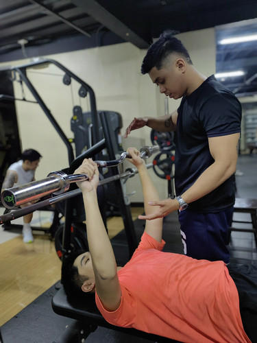 Gym coach teaching a member how to strenght train