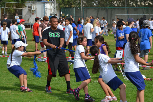 Senior Airman Henry Bones Pilligua participates in a game of tug of war with students from the Ameri.jpg