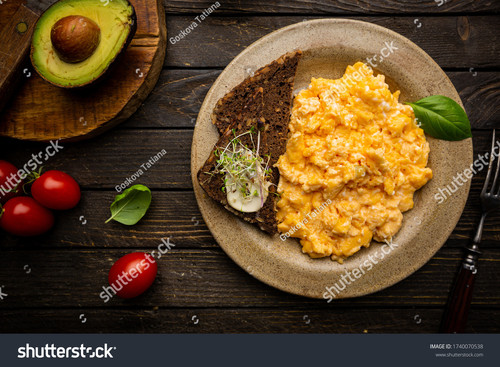 stock photo fresh cooked scrambled eggs in a plate on dark rustic wooden background top view 1740070.jpg