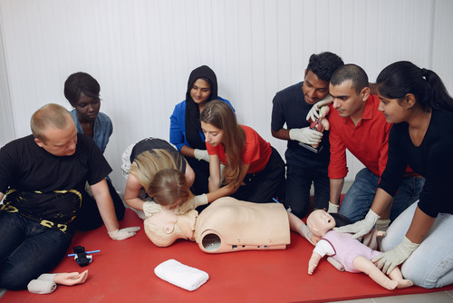 People are practicing medicine.Men and women are learning how to properly provide first aid..jpg