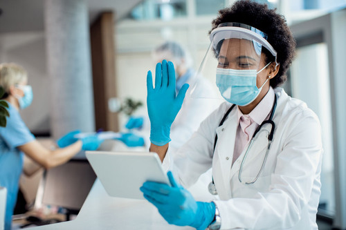 happy african american doctor waving video call while working hospital coronavirus pandemic optimize.jpg