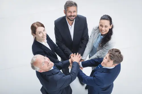 businesspeople stacking hands together.webp
