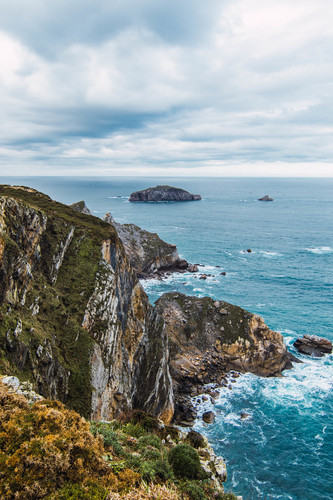 foto vertical das montanhas perto mar sob um ceu nublado em cabo penas asturias espanha.jpg