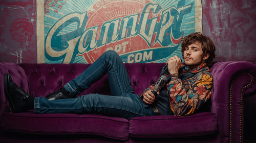 Sexy indie boy artist lying on purple couch with vintage mic; “GaanaGPT.com” in stylish retro poster.jpg