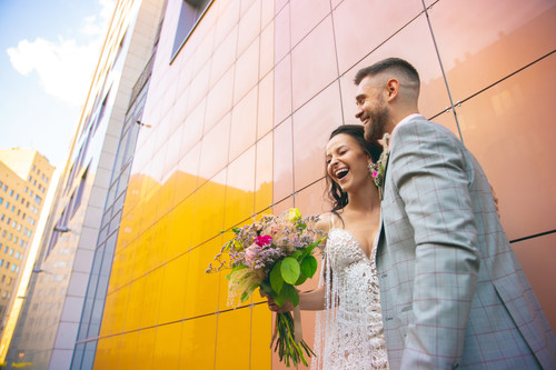 Caucasian romantic young couple celebrating marriage in city. Tender bride and groom on modern city'.jpg