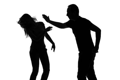 Silhouette of a man slapping a woman isolated against white background.jpg
