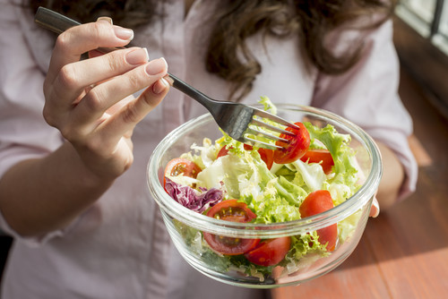 brunette woman eating salad.jpg