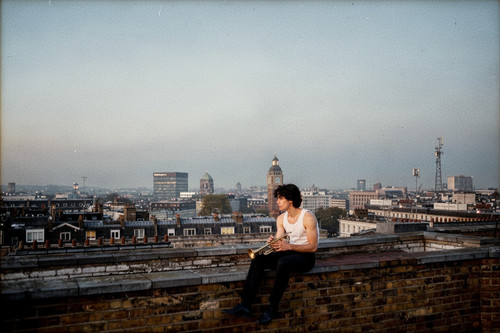 with a trumpet on his handsitting on a roof.jpg
