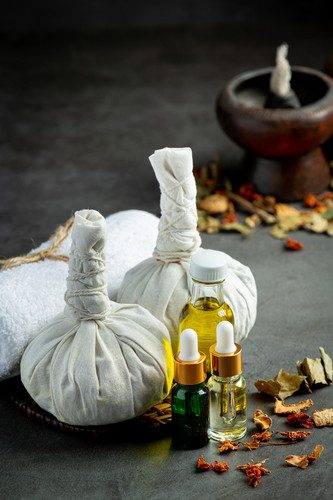 Herbal compress and herbal spa treatment equipments put on dark floor.jpg