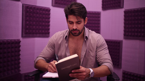 3. Handsome male Bollywood composer in an open shirt, sitting in a lavender lit studio with dark pur.jpg