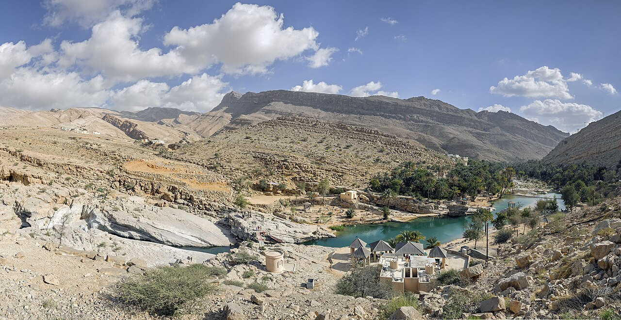 Groen water tussen rotsen en palmbomen in Wadi Bani Khalid in Oman