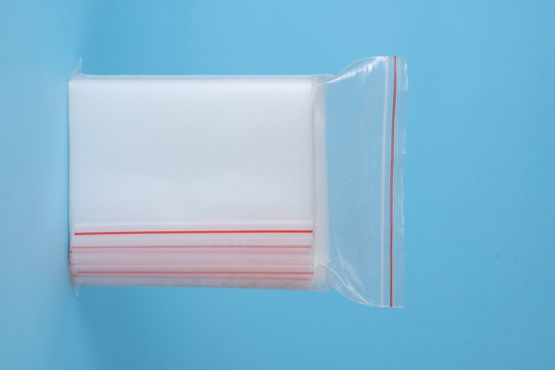 Stack of standard press-to-close PE ziplock bags with color-coded sealing line