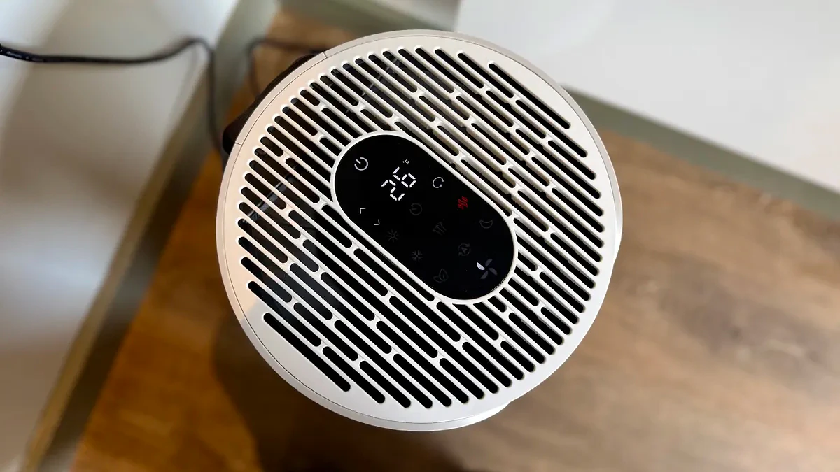 A photo of the Blueair T20i Air Purifier with its remote in a room with white walls and laminated wooden floors