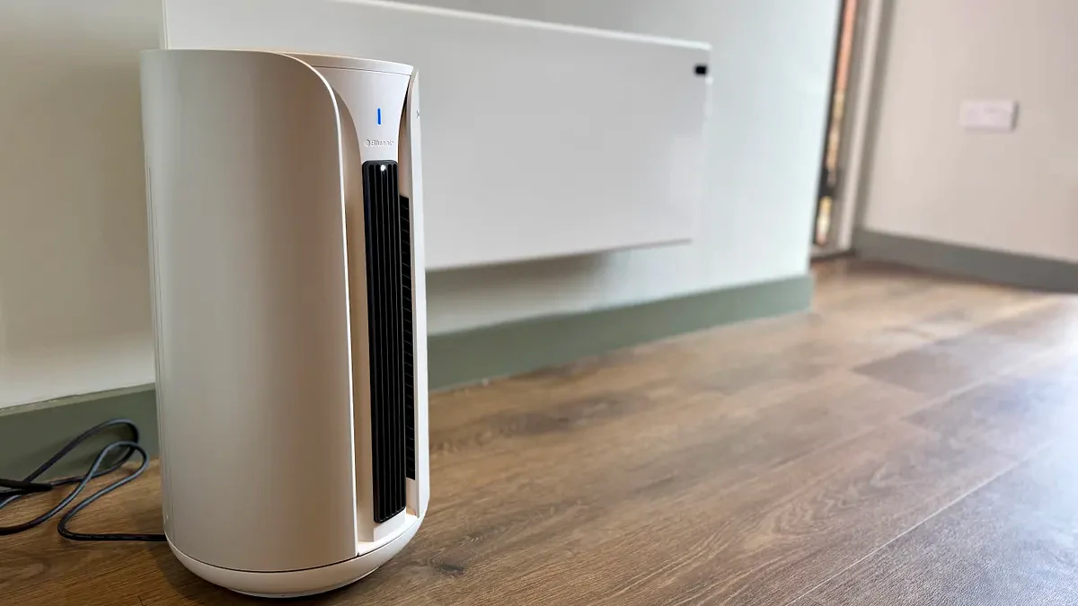 A photo of the Blueair T20i Air Purifier with its remote in a room with white walls and laminated wooden floors